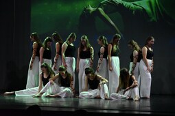 Eine gemischte Gruppe von Mädchen und Frauen führen einen Jazz Tanz auf. Die erwachsenen halten die Kinder in die Luft